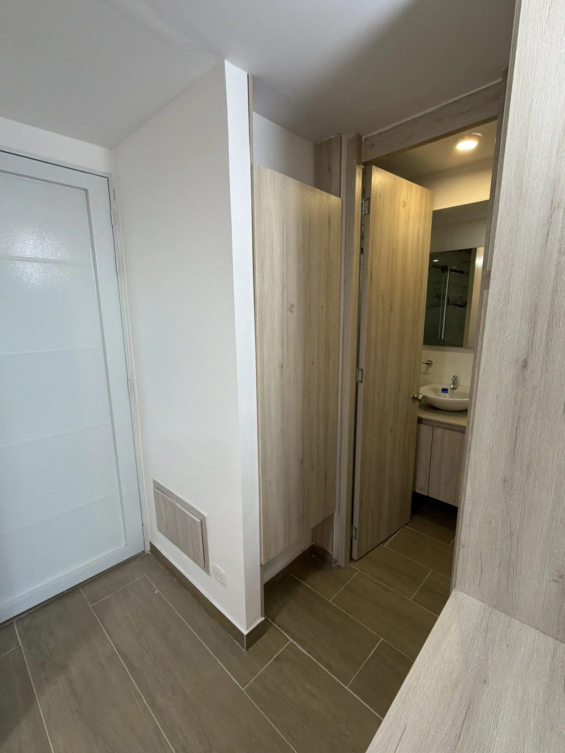 Circulación en madera clara hacia el baño.