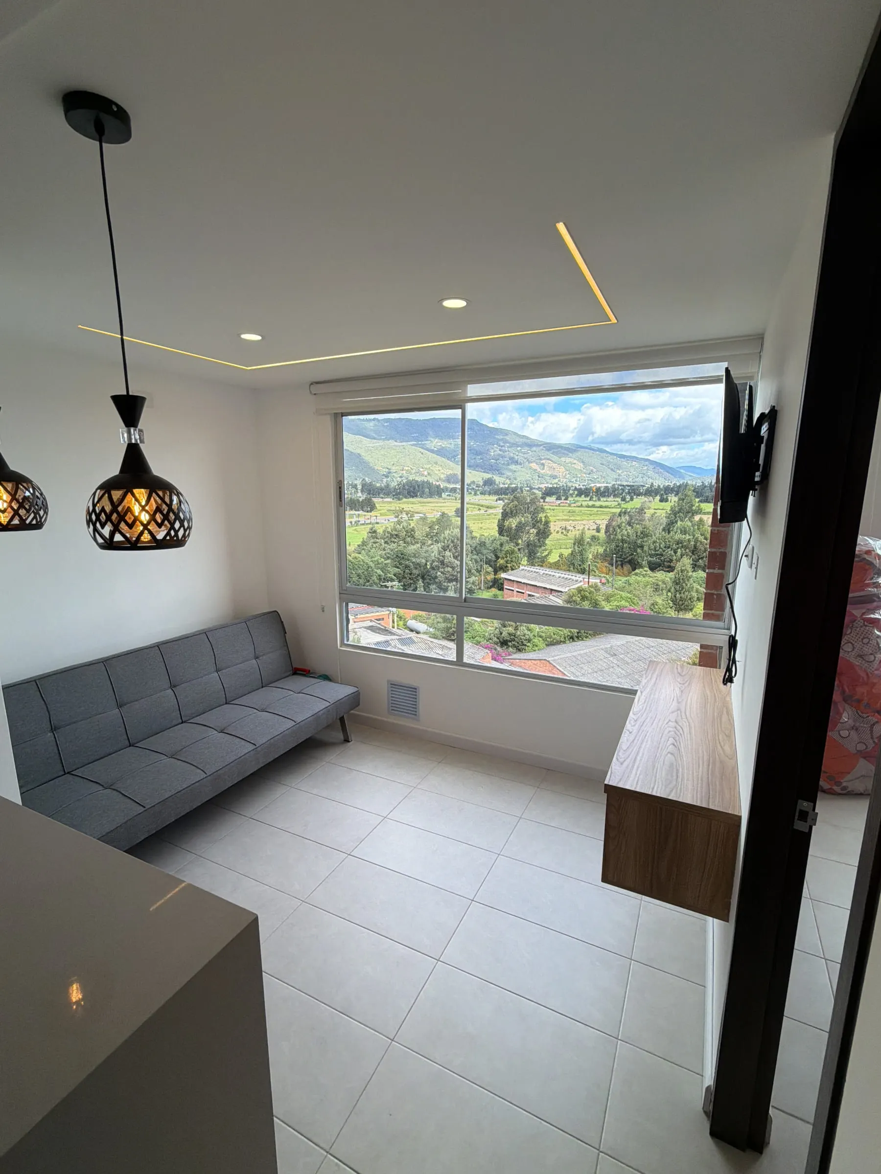 Zona de estar junto al ventanal con vista al exterior en un proyecto terminado.